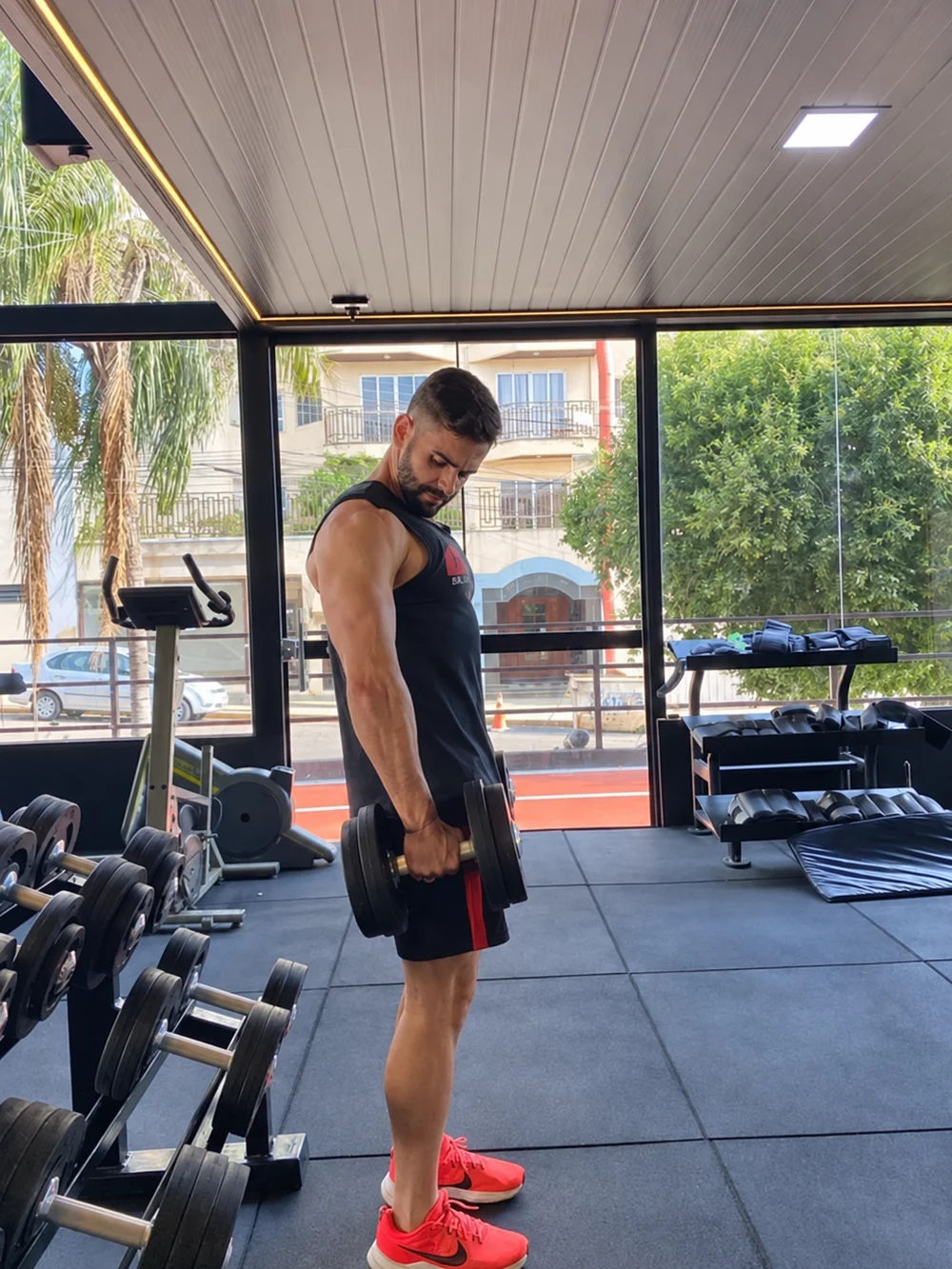 João Cleber treinando com halteres na academia